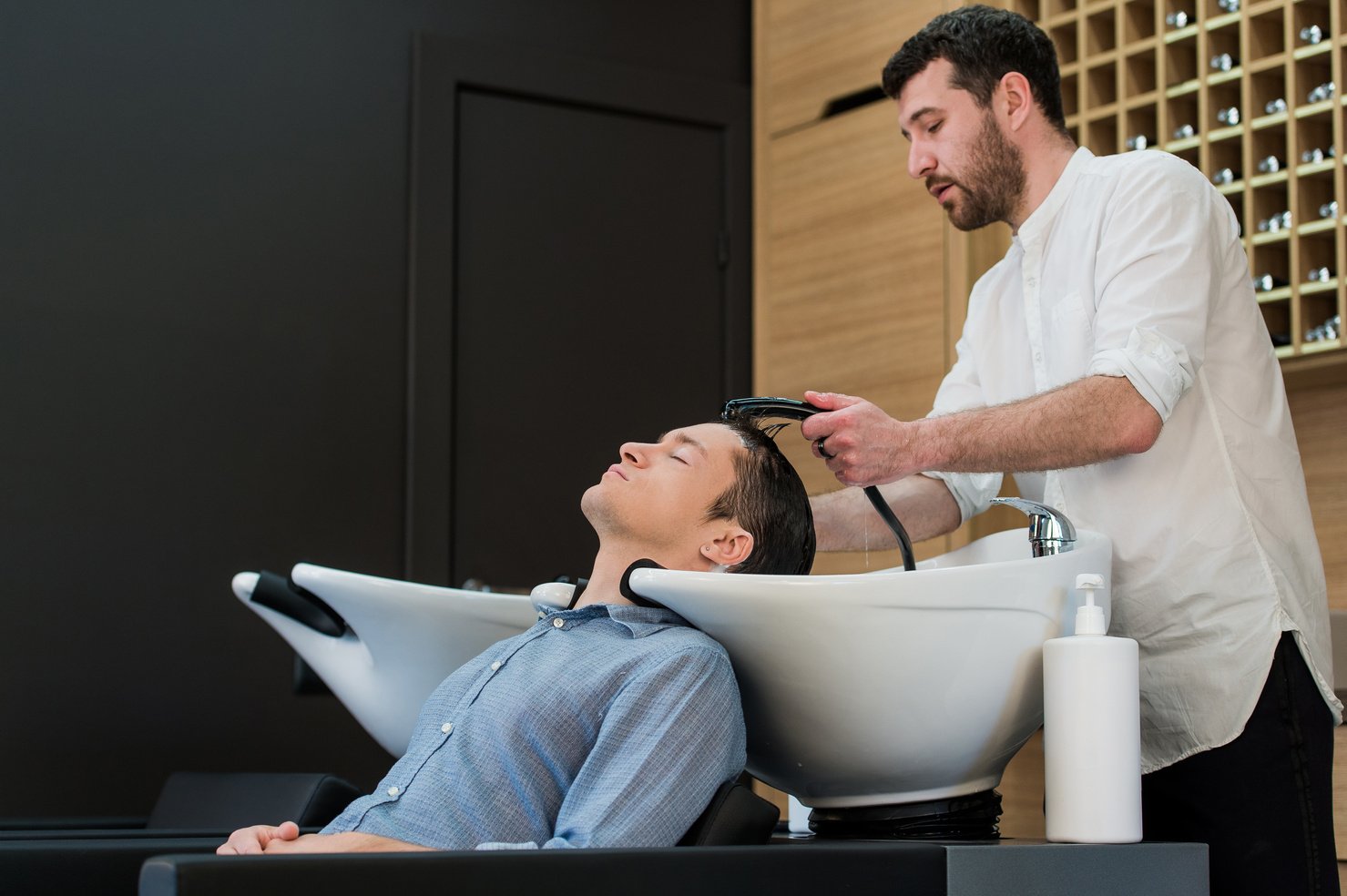 Young man at hairdresser salon getting his hair washed